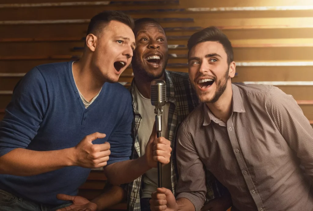 Happy friends singing karaoke together in bar